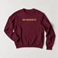 A maroon crewneck sweatshirt with the words 'OH BISCUITS' printed across the chest in a textured gold font, laid flat on a light gray background.
